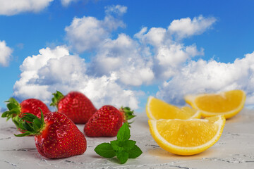 strawberries with lemon against a blue sky