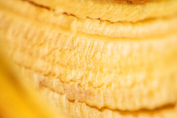Banana Peel Surface Macro. Close up view of banana peel with rough natural surface and bright yellow tone.