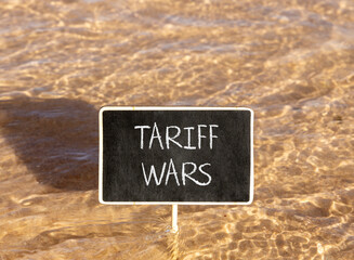 Trade tariff wars symbol. Concept word Tariff wars on beautiful black blackboard. Beautiful Red sea...