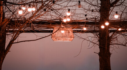 Atardecer en el Lago Piedras Moras en Almafuerte, Córdoba, Argentina, paisaje natural con reflejos rosados en el agua y restaurante iluminado junto a la orilla. © Jesus