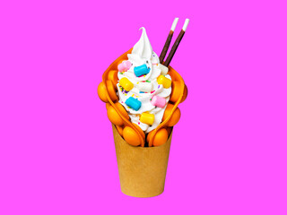 bumble waffles with different fruits in a cup on a pink background.