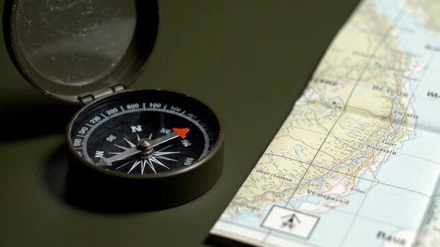 Vintage compass resting beside a detailed map, highlighting navigation tools and exploration