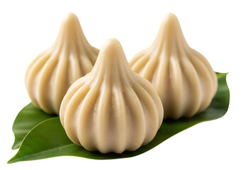 Obraz premium Three sweet indian modak dumplings made of rice flour and jaggery on green leaves isolated on transparent background