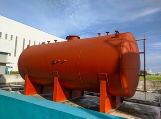 A large red horizontal industrial tank.