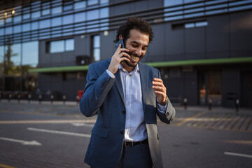 Businessman talking on smart phone outside office building