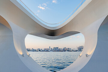 Romantic heart-shaped view from Creek Harbour Public Viewing Deck in Dubai, framing the skyline and Dubai Creek waterfront with calm water and soft evening light