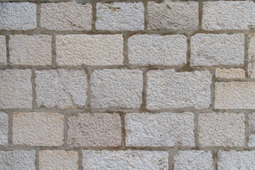 Coursed ashlar limestone wall texture with mortar joints