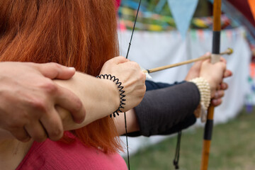 A woman learns archery at a historic festival