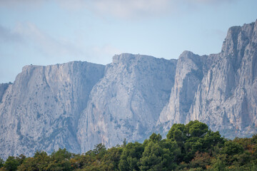 Mountains Landscape Nature - Majestic mountain range with rugged cliffs and lush greenery under a clear blue sky.