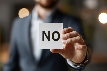 A Professional Dressed Individual Holds a Card Displaying the Bold Word 'NO,' Reflecting a Firm Denial or Rejection in a Modern Business Environment