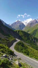 Winding mountain road ascends through lush greenery