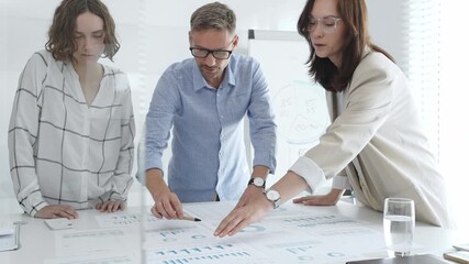 Business team analyzing financial data and discussing growth strategies during a productive meeting in a modern office. Business people concept - Powered by Adobe