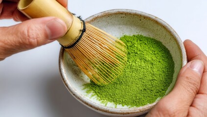 Preparing green matcha tea with a bamboo whisk in a ceramic bowl is part of a morning mindfulness routine that fosters a calm and peaceful beginning to the day