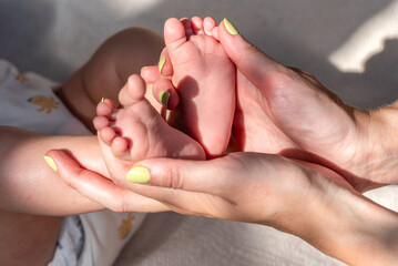 the baby s small feet in her mother s arms. Mom and her Child. Happy Family concept.