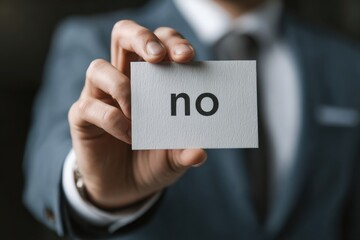 A Businessman Holding a Card Displaying the Word 'No', Signifying Refusal or Disagreement in a Professional Setting
