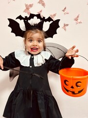 Cute little girl in scary vampire costume screaming on Halloween party