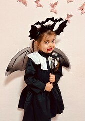 Cute little girl in scary vampire costume screaming on Halloween party