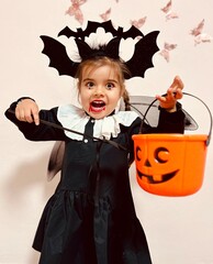 Cute little girl in scary vampire costume screaming on Halloween party