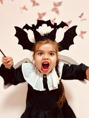 Cute little girl in scary vampire costume screaming on Halloween party
