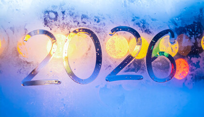 Fototapeta premium 2026 Written on a Frozen Glass Window with Colorful Bokeh Lights Shining Through