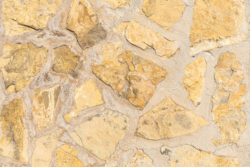 A beautiful texture of path or wall of orange and yellow stones is in the park