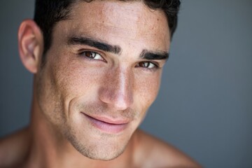 Fototapeta premium Close Up Portrait of Smiling Young Man with Clear Skin and Short Dark Hair.