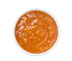 orange jam in a white ceramic  bowl isolated on white background, top view.