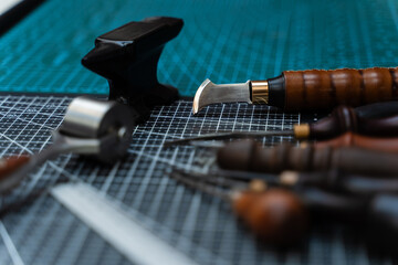 Leathercraft Tools on Workbench. Traditional wooden-handled awls and cutters beside a small anvil...