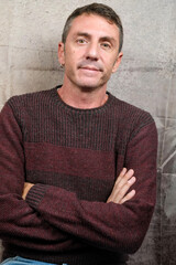 Fototapeta premium Portrait of a man wearing a burgundy wool sweater. The man is forty years old and of Caucasian origin