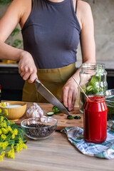 Cucumber being sliced by hands in a kitchen, surrounded by spices, garlic, and jars, showcasing the art of pickling and preservation with vibrant colors and textures