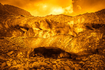 Fantasy orange color effect of ice breakup of the Vallelunga glacier tongue, Alto Adige, Italy. The glacier is in rapid retreat caused by global warming