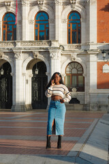 Fototapeta premium Black woman talking on smartphone in urban setting