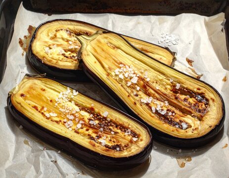 Salty roasted eggplant on parchment paper in a kitchen setting Generative AI