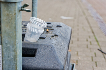 Heavy road sign bases used as litter bin with cups and butt