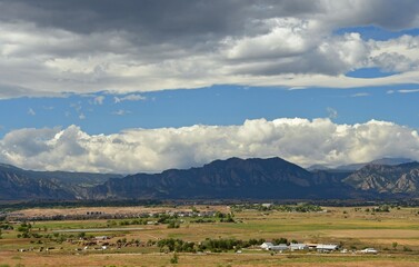 Fototapeta premium looking out toward stearns lake, boulder's flatirons, and eldorado canyon in the rocky mountains' front range, over farmland and open space on a sunny fall day, from Broomfield. colorado