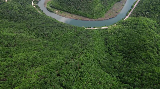 Drone view of a dramatic river bend in Ovcar-Kablar Gorge, Serbia, showing the winding West Morava River surrounded by lush green hills. Horizontal 4k footage