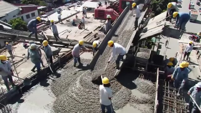 Construction workers pouring concrete on a construction site for building.