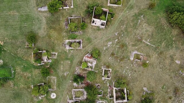 Destroyed village in war, aerial drone view. Ruined and damaged house in village as war aftermath. Houses destroyed and burned by artillery during the war. Houses in ruins. 