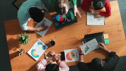 Top down view of business woman explain and present financial chart. Diverse group discuss and listen presentation about stock market statistic at meeting table with investment graph. Convocation. - Powered by Adobe