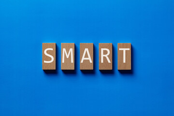 Obraz premium There is wood block with the word Smart. It is as an eye-catching image.