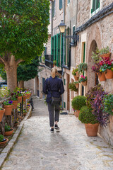 Woman walking through plant filled stairway of Valldemossa Spain