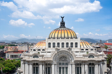 Fototapeta premium The building is a large dome with a gold and yellow roof. The building is in a city with a lot of buildings. Palace of Fine Arts, Mexico City, Zocalo, Bellar Artes