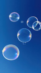 Naklejka premium Floating Soap Bubbles Reflecting Rainbow Colors Against a Bright Blue Sky, Symbolizing Joy and Carefree Moments