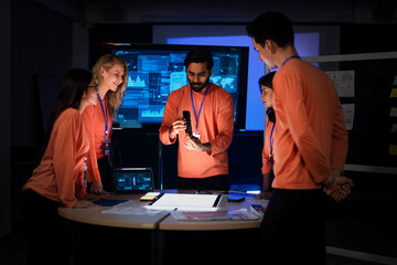 A cybersecurity team in a Security Operations Center analyzes a global threat map. They are collaborating on an incident response, tracking network intrusions in real-time.