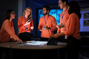 A team of hardware engineers and UI UX designers reviews a new smartphone prototype. They are analyzing the device's ergonomics and the mobile operating system's user flow.
