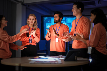 A development team shows satisfaction after a successful product launch. They are reviewing the final app on their smartphones, celebrating a flawless execution of their project.