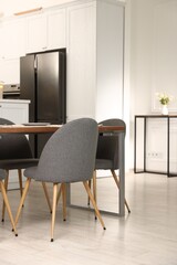 Kitchen interior with dining table, place setting and grey chairs