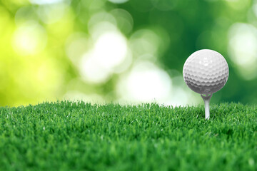 Golf ball on green grass against blurred background