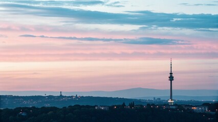 A City Silhouette Against a Serene Pastel Sunrise or Sunset
A Hazy Urban Skyline at Dawn with a Tall Tower in the Foreground
Tranquil Cityscape with Soft Pastel-Colored Sky and Hazy Buildings