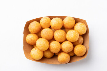 Top view of deep fried sweet potato balls in paper bowl on white background, Thai street food snack